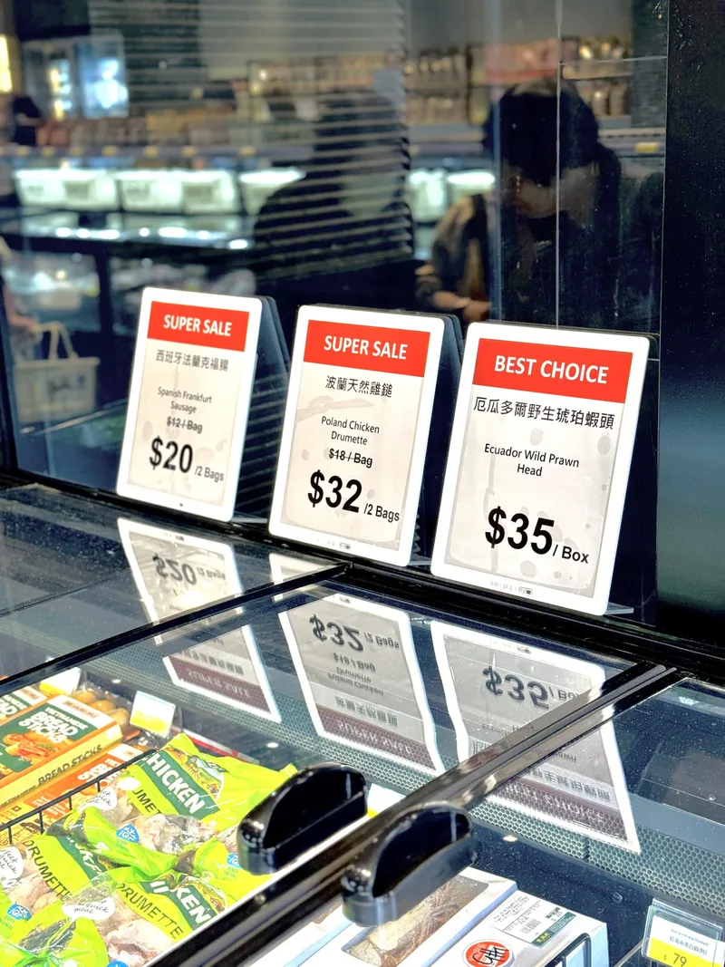 Three red, black and white ePaper price displays showing Super Sale and Best Choice offers above a supermarket freezer