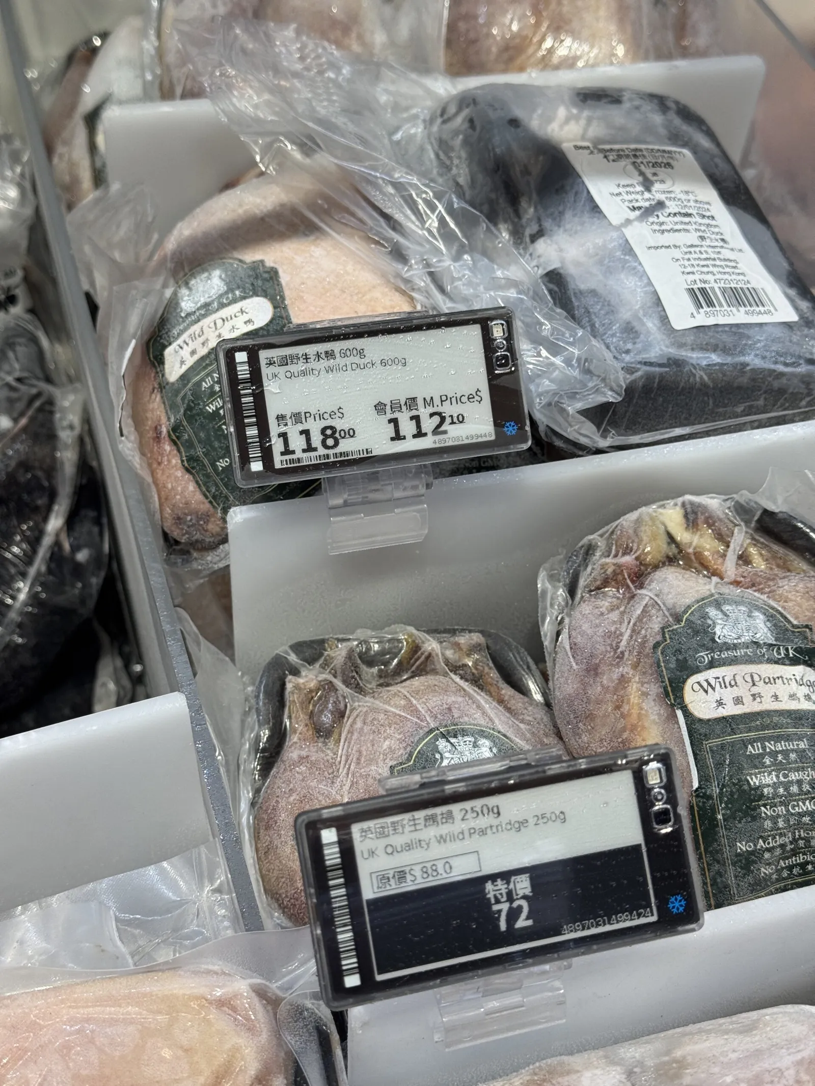Black-and-white electronic shelf labels showing regular and member prices for frozen wild duck and partridge