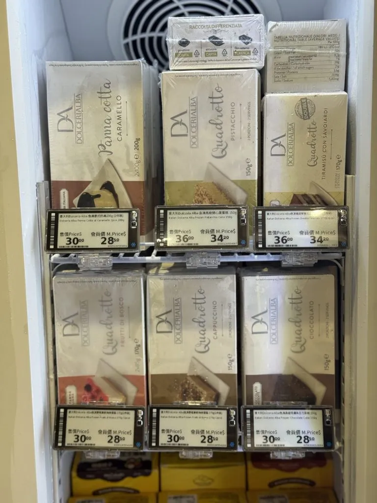 Two rows of electronic shelf labels with regular and member prices on frozen Italian desserts in a freezer