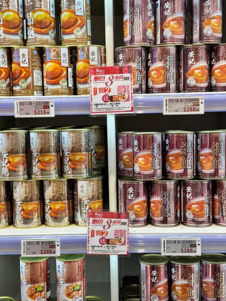 Electronic shelf labels and printed promotion cards on shelves of canned abalone