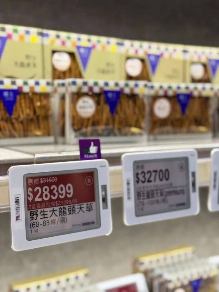 Electronic shelf labels, one with a red promotion price, on a shelf of boxed dried cordyceps
